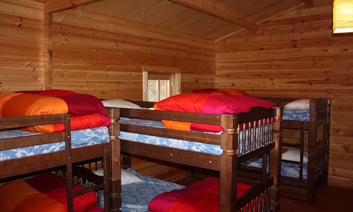 Literas de madera en los bungallows de madera en el albergue de la serrania de Cuenca